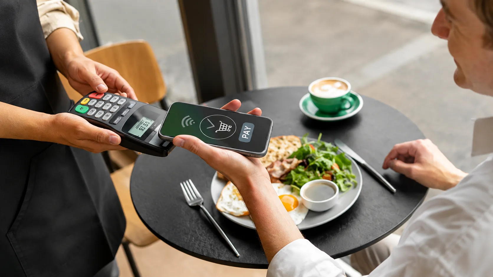 Customer making a contactless payment at a restaurant